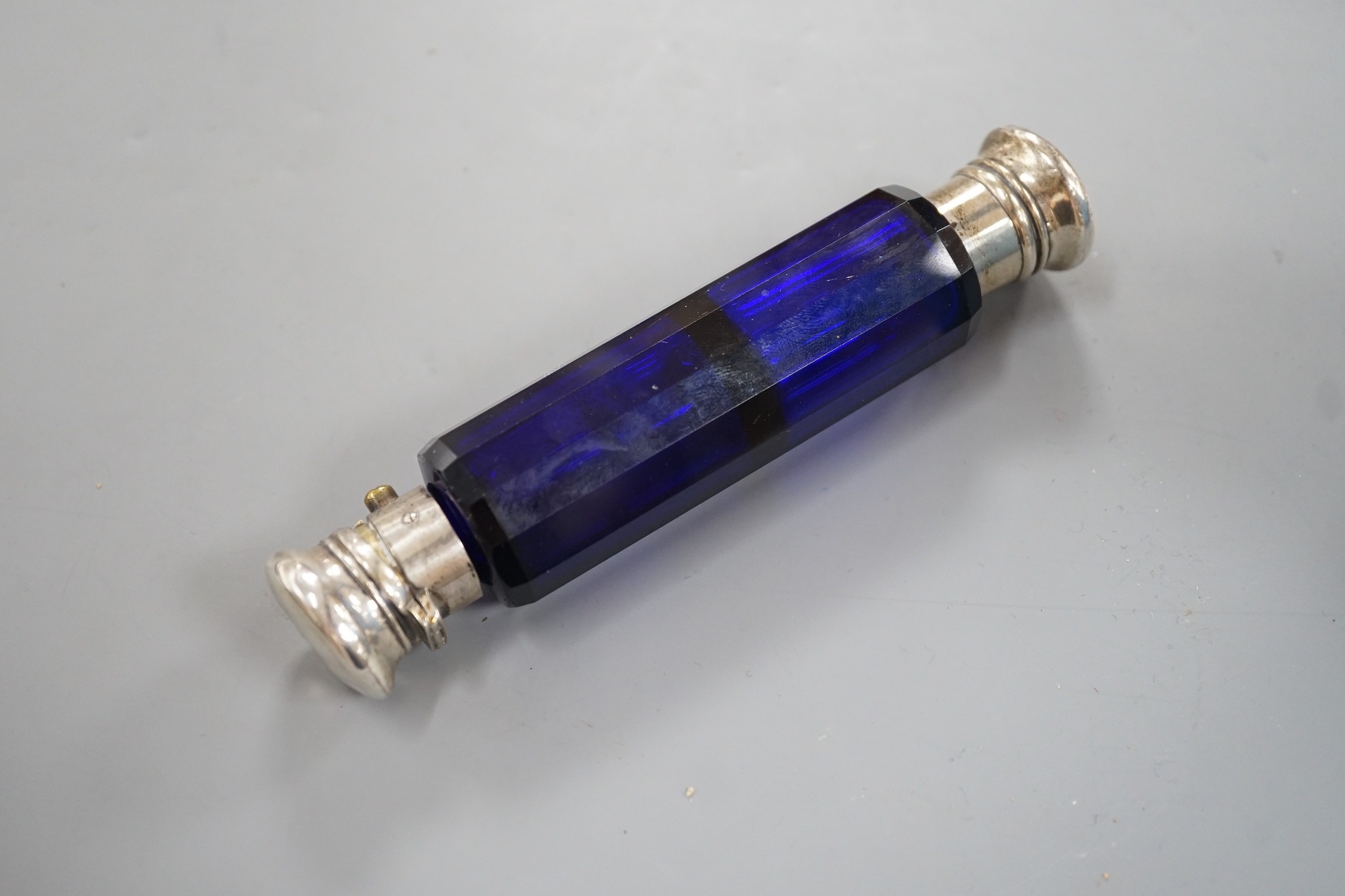 A late Victorian white metal mounted blue glass double ended scent bottle, 13.5cm.